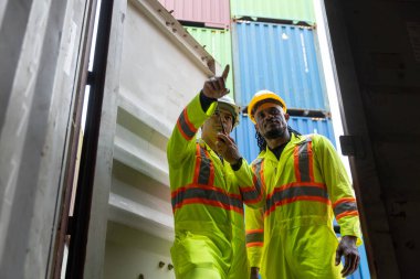 Çok ırklı ve siyah Afro-Amerikan erkek işçiler konteynır limanındaki malları denetliyor. Kargo taşımacılığı endüstrisi terminal taşımacılığı ithal ve ihraç. 