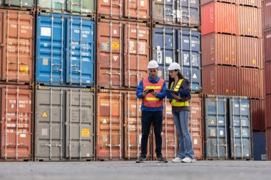 Konteynır lojistik nakliyesi, Foreman çalışanı ve Endüstriyel Mühendis kadınlar terminal nakliye mallarındaki konteynırları kontrol ediyorlar. Depo ithalatı - Endüstriyel ihracat.
