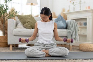 Genç bayan omuz egzersizi yapıyor. Kol egzersizi yapıyor. Kas ağırlığı çalışıyor..