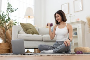 Genç bir bayan omuz çalışıyor. Kol egzersizi yapıyor. Çevrimiçi egzersiz yapıyor..