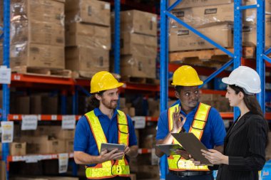 Depo çalışanları, depolama bölümündeki ürünlerin envanter ve danışmanlık dağılımını kontrol etmek için çok ırklı tartışmalar yapıyorlar. Denetleyici malların denetlenmesi ve yerleştirilmesini tavsiye ediyor