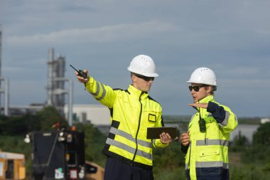 Ekip mühendisi inşaat alanında petrol rafinerisini gözlemliyor. Endüstriyel bölgede enerji petrokimya araştırması.