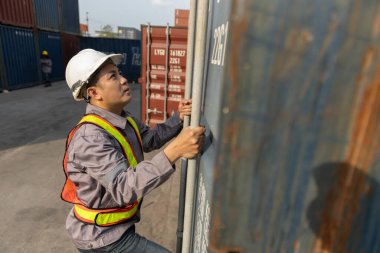 Erkek işçiler konteynır limanındaki kapıları kontrol ediyor. Kargo taşımacılığı endüstrisi terminal taşımacılığı ithal ve ihraç.