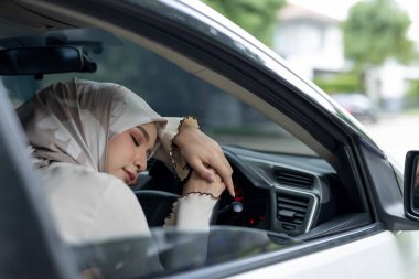 Müslüman kadınlar direksiyonda arabada uyurlar. Araba sürerken uykulu hissediyorum. Uykun geldiğinde, dinlenmek için araba sürmeyi bırakmalısın..