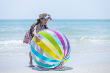 Küçük kız güneşli bir günü gündüz vakti top oynayarak, mutlu çocuklar denizde oynayarak, sınıf dışında öğrenerek geçirir. Parlayan su komik atmosferi över..