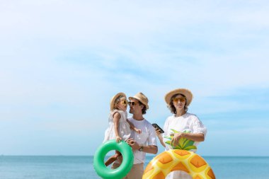 Neşeli aile yaz tatilini plajda, güneş gözlüğü ve hasır şapka takarak, şişme yüzme yüzükleri tutarak, denizde eğlenerek ve gün ışığıyla geçiriyor. Baba, anne ve kız..