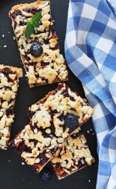 Nane şekeriyle süslenmiş siyah bir tabakta reçelli ev yapımı turta. Dikey.