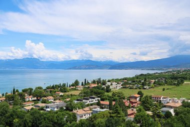 Garda Gölü 'nün yukarısından panoramik manzara, mavi su ve kıyıdaki köy