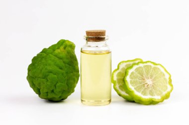 Şişedeki Bergamot yağı ve beyaz arka planda izole edilmiş taze bergamot meyvesi..