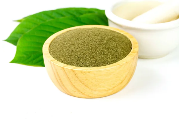 Mitragyna Speciosa Korth veya kriatom tozu, beyaz arka planda yeşil yapraklı ahşap kase içinde..