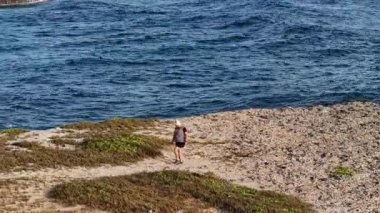 Karayipler 'deki bir adanın ıssız sahillerinde bir kadın.