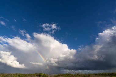 Fırtınalı bulutların üzerinde gökkuşağı  