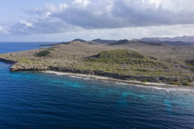 Karayip Denizi 'ndeki Curacao kıyılarının havadan görünüşü. Turkuaz su, uçurum, sahil ve Playa Manzalina etrafındaki güzel mercan resifleri.