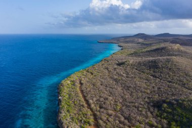 Karayip Denizi 'ndeki Curacao kıyılarının havadan görünüşü. Turkuaz su, uçurum, sahil ve Playa Manzalina etrafındaki güzel mercan resifleri.