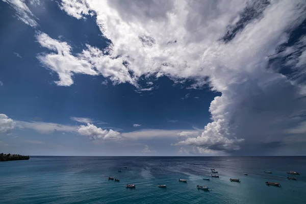 Curacao ve Karayipler 'in etrafındaki turkuaz denizin üzerinde uçan bulutlarla dolu sağanak manzarası.