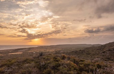 Karayipler 'deki bir adadaki dağların üzerinden gün batımı manzarası