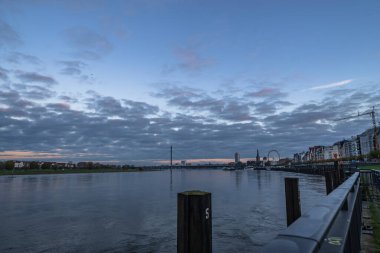 Almanya 'da Ren nehrinde Dusseldorf' un ufuk çizgisinin gün batımı manzarası