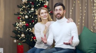 Yetişkin, evli bir çift, eşler Mutlu Yıllar 'ı kutluyor, internette uzaktan evde oturup kameraya bakarak mutlu Noeller diliyor. Karı koca selamlaşması. webcam Görünümü