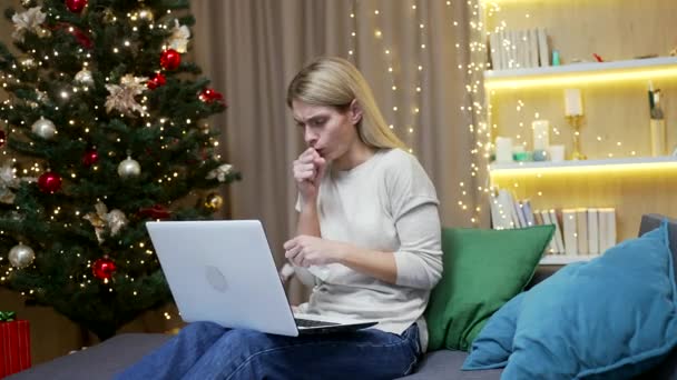 新年假期里 女人一个人坐在沙发上 躺在客厅里 在圣诞节里咳嗽 在冬季发炎的肺期间 生病的雌性感染了感冒 自由职业者的工作 — 图库视频影像