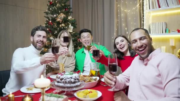クリスマスの前夜祭の若者 お祝いの友人は ソーシャルメディアのオンラインコールオーディエンスでパーティーの家で見るためにライブストリーミングを持っています スマートフォンを使って家でカメラを見る — ストック動画