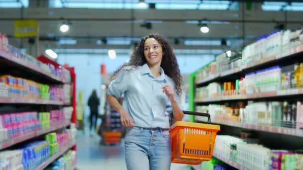商店里快乐的年轻妇女顾客手里拿着篮子 在超市里的两排舞跳着滑稽的舞 在杂货店里散步 边跳舞边购物 — 图库视频影像