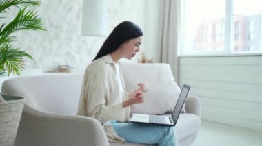 Oturma odasındaki koltukta oturmuş psikoterapist terapistle ağlayan bunalımlı genç bir kadın dizüstü bilgisayarın psikolojik desteğiyle ilgili sorunları tartışıyor.
