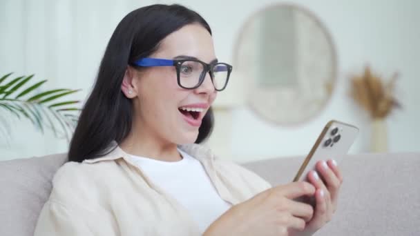 Aşırı Neşeli Koyu Renk Saçlı Kadın Evinde Akıllı Telefondan Harika — Stok video