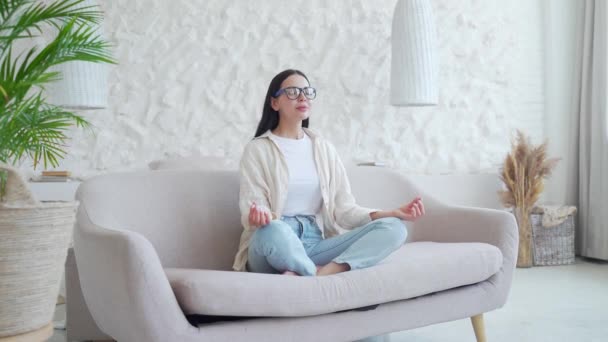 Aydınlık Oturma Odasındaki Kanepede Nilüfer Çiçekli Gözlüklü Genç Kadının Portresi — Stok video