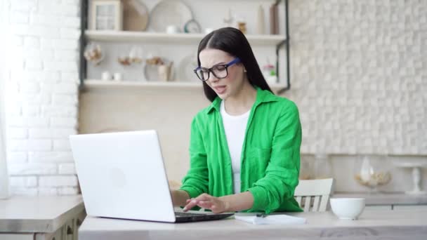 Młoda Kobieta Okularach Siedzi Jasnej Kuchni Denerwuje Się Problemami Laptopem — Wideo stockowe