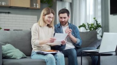 Çıkan genç aile açık zarf içinde harika haberler iyi tıbbi testler ya da sorgu sonuçları evdeki koltukta oturan mutlu ve mutlu bir çift mektup aldı ve zaferi kutladı.