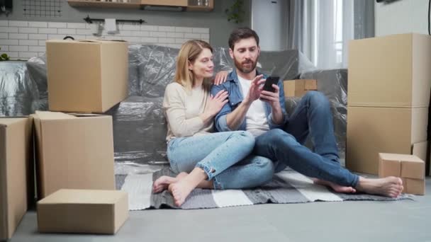 부부는 온라인 매장에서 스마트폰을 이용해 새로운 거실에 스마트 이용해 아파트 — 비디오