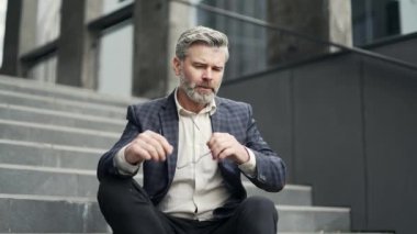 Stresli, olgun iş adamının modern iş merkezinin merdivenlerinde oturması işsizlik sorununu kaybettiği için kendini kötü hissetmesi üzgün çalışanın işsizlikten umudunu kesmesi. 