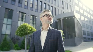 Klasik takım elbiseli başarılı bir iş adamının portresi. Etrafına bak. Modern iş merkezinin keyfini çıkar. 