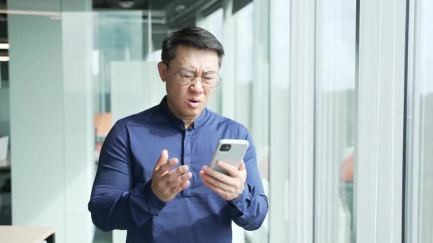 Нервный Разочарованный Азиатский Бизнесмен Программист Очках Получил Электронное Сообщение Смартфоне — стоковое видео