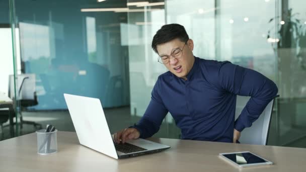 在现代工作场所 工作倦怠过度的亚洲商人It程序员在办公桌前辛勤工作 背痛难忍 — 图库视频影像