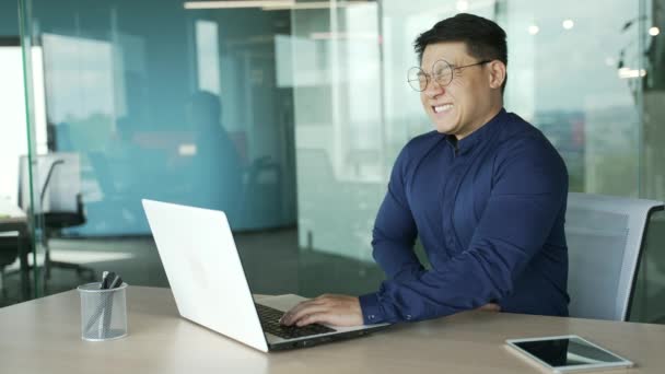在现代工作场所 生病的亚洲商人It程序员 戴着眼镜 患有胃炎 感觉很糟 不健康的员工在室内抱着肚子 消化不良或中毒 — 图库视频影像