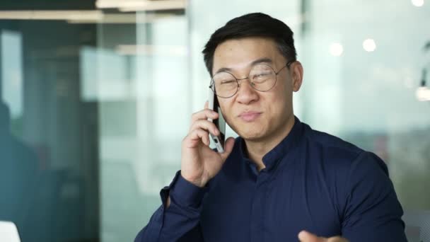 Confiante Asiático Empresário Programador Com Óculos Falando Telefone Celular Escritório — Vídeo de Stock