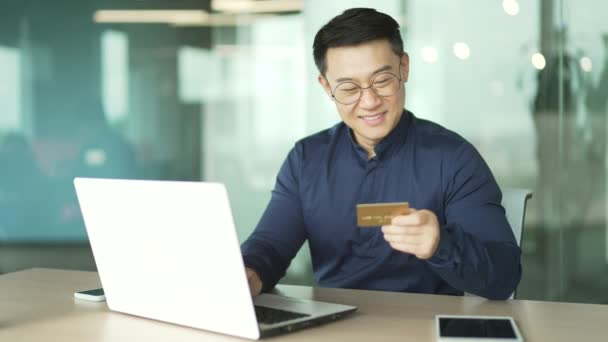 Sorrindo Asiático Programador Empregado Pagando Com Cartão Crédito Laptop Escritório — Vídeo de Stock