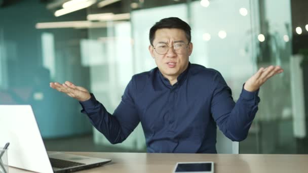 Zmatený Asijský Podnikatel Zaměstnanec Sedí Vedle Notebooku Pokrčení Ramen Váhání — Stock video