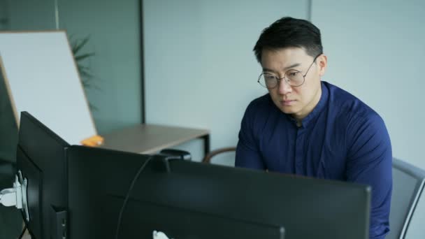 안경을 바쁘게 일하는 전문가 프로그래머는 회사에서 아시아 기업가 개발자로 일하는 — 비디오