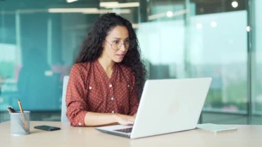 Genç mutlu kadın çalışan profesyonel yönetici iyi haber mesajı alıyor gülümseyen iş kadını bilgisayara bakıyor işyerinde oturuyor evet kazandı diye haykırıyor.