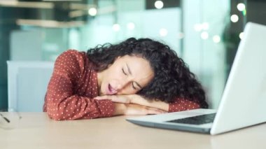 Yorgun iş kadını ofis çalışanı ya da iş yerinde uyuyan tezgahtar. Masa başında uyuyakalan aşırı yüklenmiş iş kadını. Masadaki iş yerinde yorgun ve bitkin bir kadın.