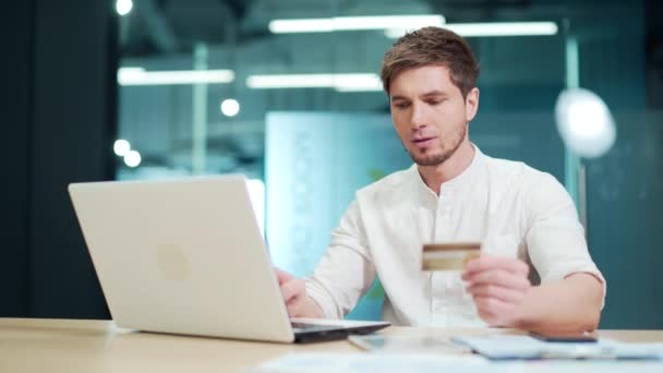 Young Smiling Worker Holding Credit Card While Sitting Laptop Modern — Vídeos de Stock