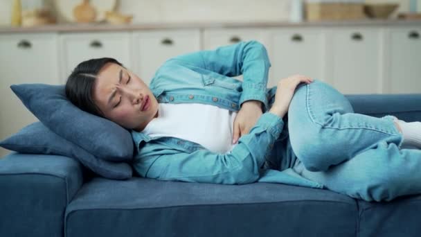 Sick Young Asian Woman Feeling Stomach Ache While Lying Sofa — Wideo stockowe