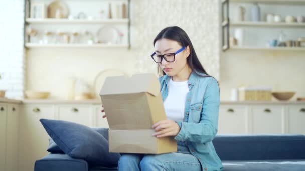 Young Asian Woman Disappointed Package She Opened While Sitting Sofa — Stock Video