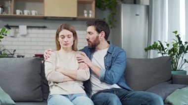 Suçlu sakallı koca, aile içi çatışmalardan sonra üzgün genç kadından özür dilemeye çalışıyor. Genç adam karısını iş yerinde ya da kişisel akıl sağlığı krizinde sakinleştiriyor ve destekliyor.