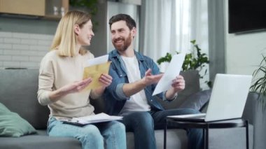 Çıkan genç aile açık zarf içinde harika haberler iyi tıbbi testler ya da sorgu sonuçları evdeki koltukta oturan mutlu ve mutlu bir çift mektup aldı ve zaferi kutladı.