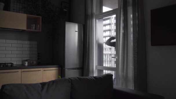 Durch Die Glastür Des Wohnzimmers Ist Ein Mann Schwarzer Kleidung — Stockvideo