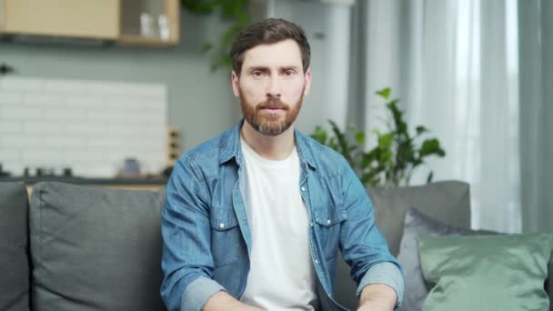 Mature Caucasian Man Looking Camera Listens Talking Sitting Sofa Home — Stockvideo