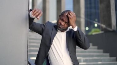 Depresyonda olan Afro-Amerikan olgun bir adam dışarıda bir ofis binasının önünde bir sorun düşünüyor. Resmi takım elbiseli üzgün bir işadamı eliyle başını tutuyor. İflas kavramı